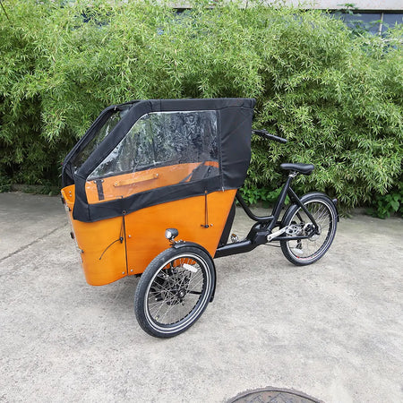 Weatherproof rain cover protecting cargo box on rainy-day e-trike ride